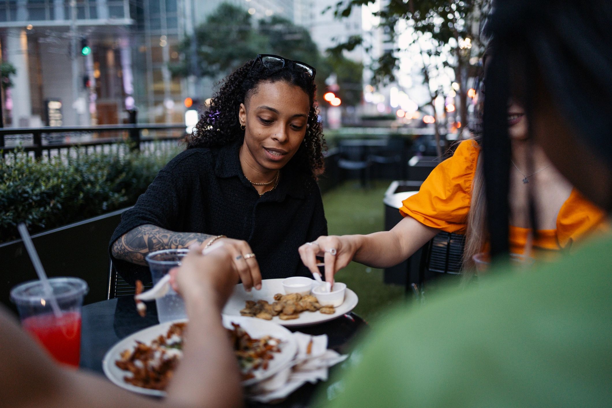 Friends enjoying food and drinks at an outdoor restaurant